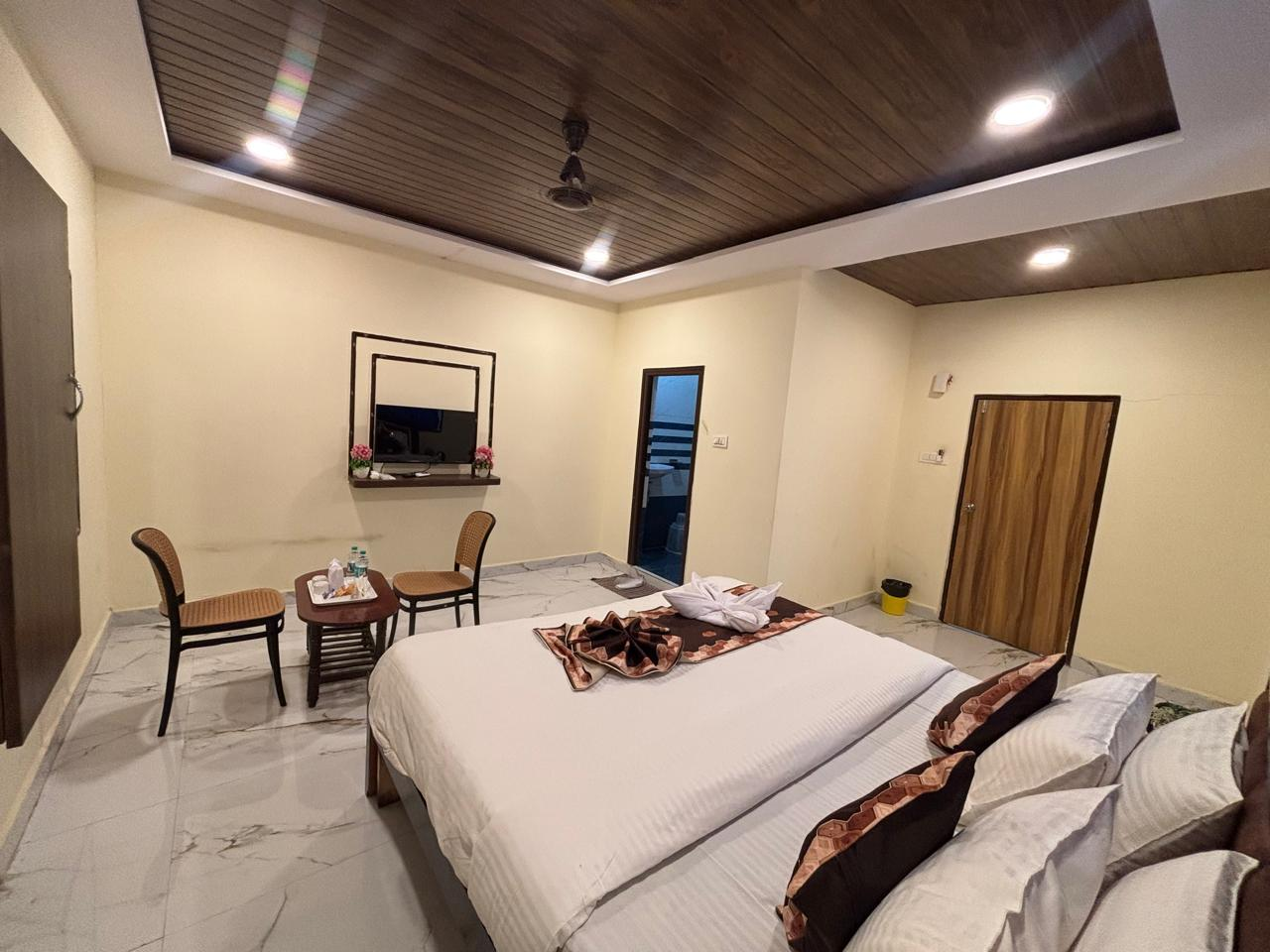 Deluxe AC Room with decorated bed and seating area